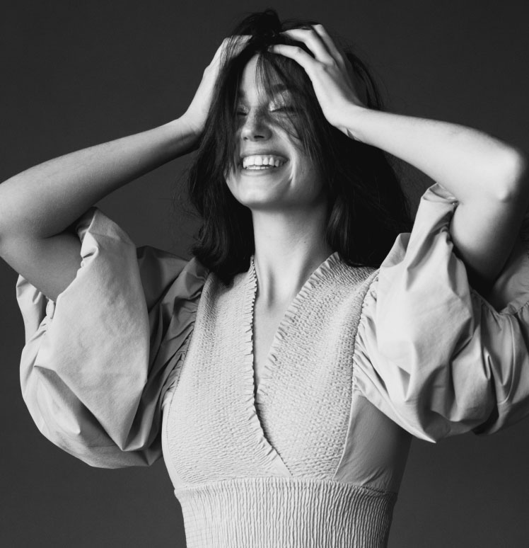 Woman with Hands in Hair Smiling